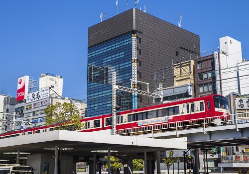 「川崎」駅東口の高架線路を走る京浜急行線の赤い車両