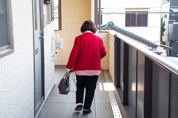 共用廊下を歩く高齢女性