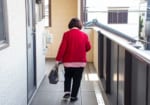 共用廊下を歩く高齢女性