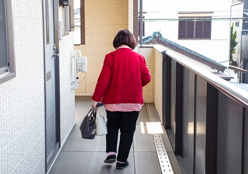 共用廊下を歩く高齢女性
